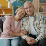 Older person and a younger family member sharing a warm, supportive moment together in a brightly lit, comfortable home.