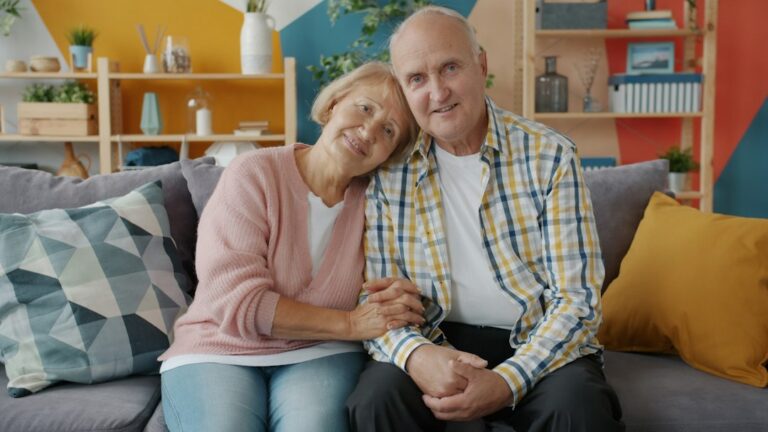 Older person and a younger family member sharing a warm, supportive moment together in a brightly lit, comfortable home.