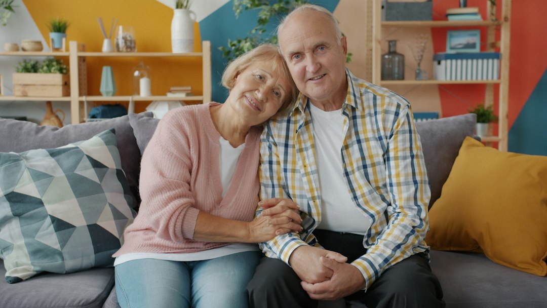 Older person and a younger family member sharing a warm, supportive moment together in a brightly lit, comfortable home.